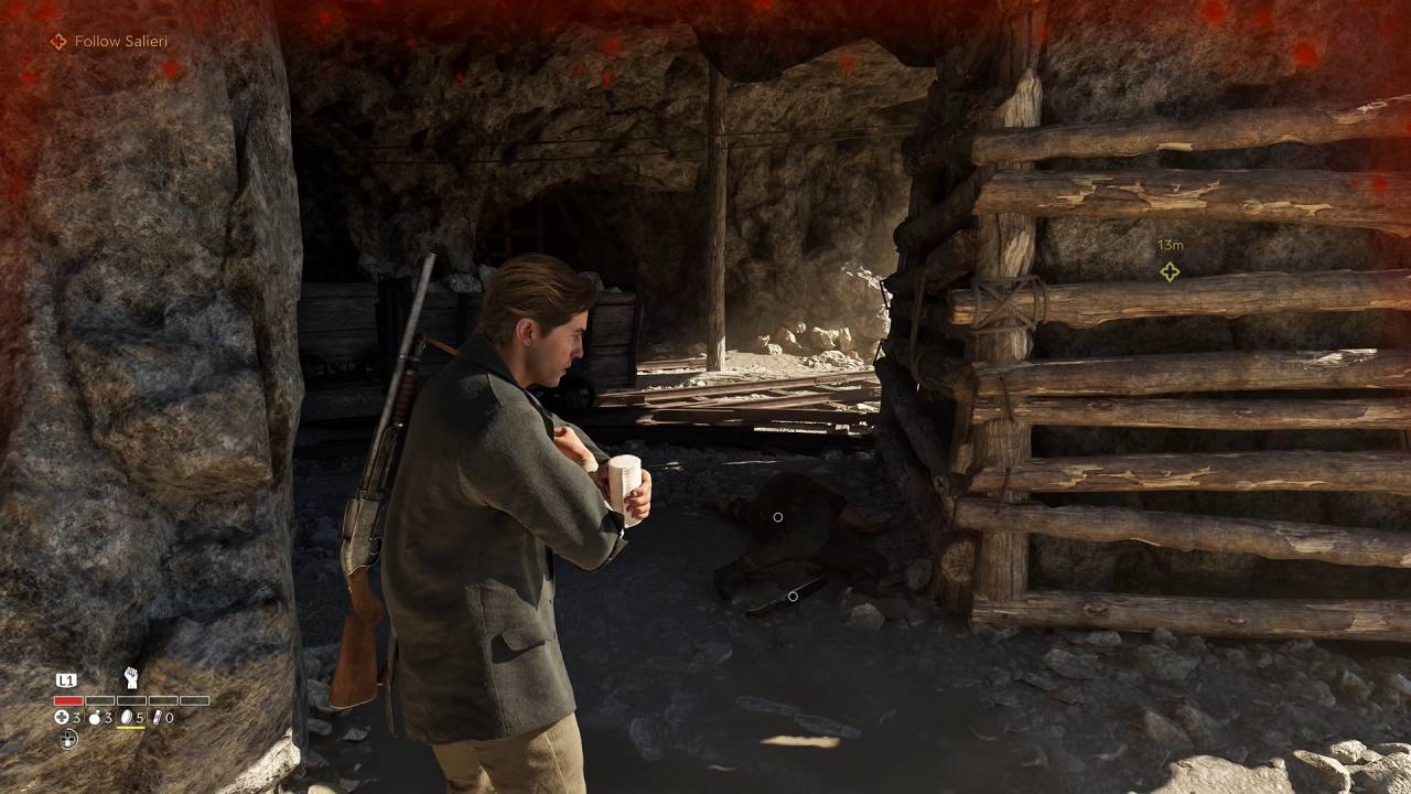 Mafia: The Old Country - Man of Honor Enzo bandaging himself inside a cave